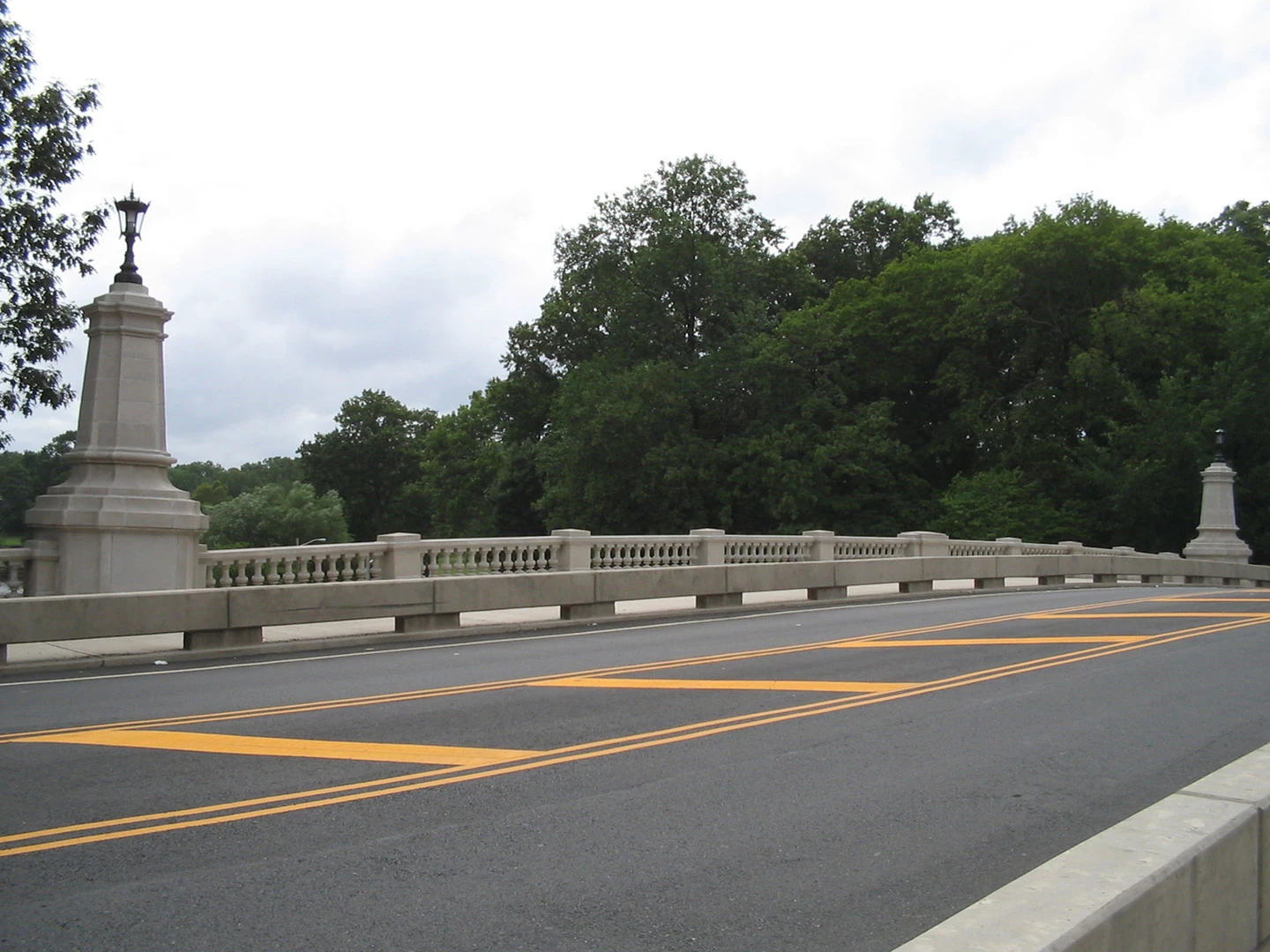 A road with yellow lines and trees in the background