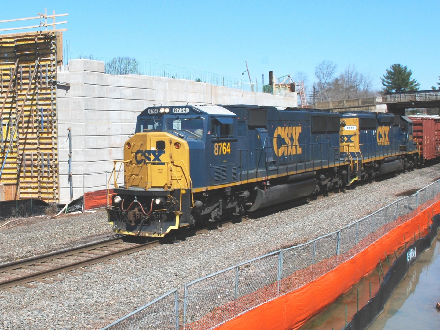 A train is on the tracks near a fence.