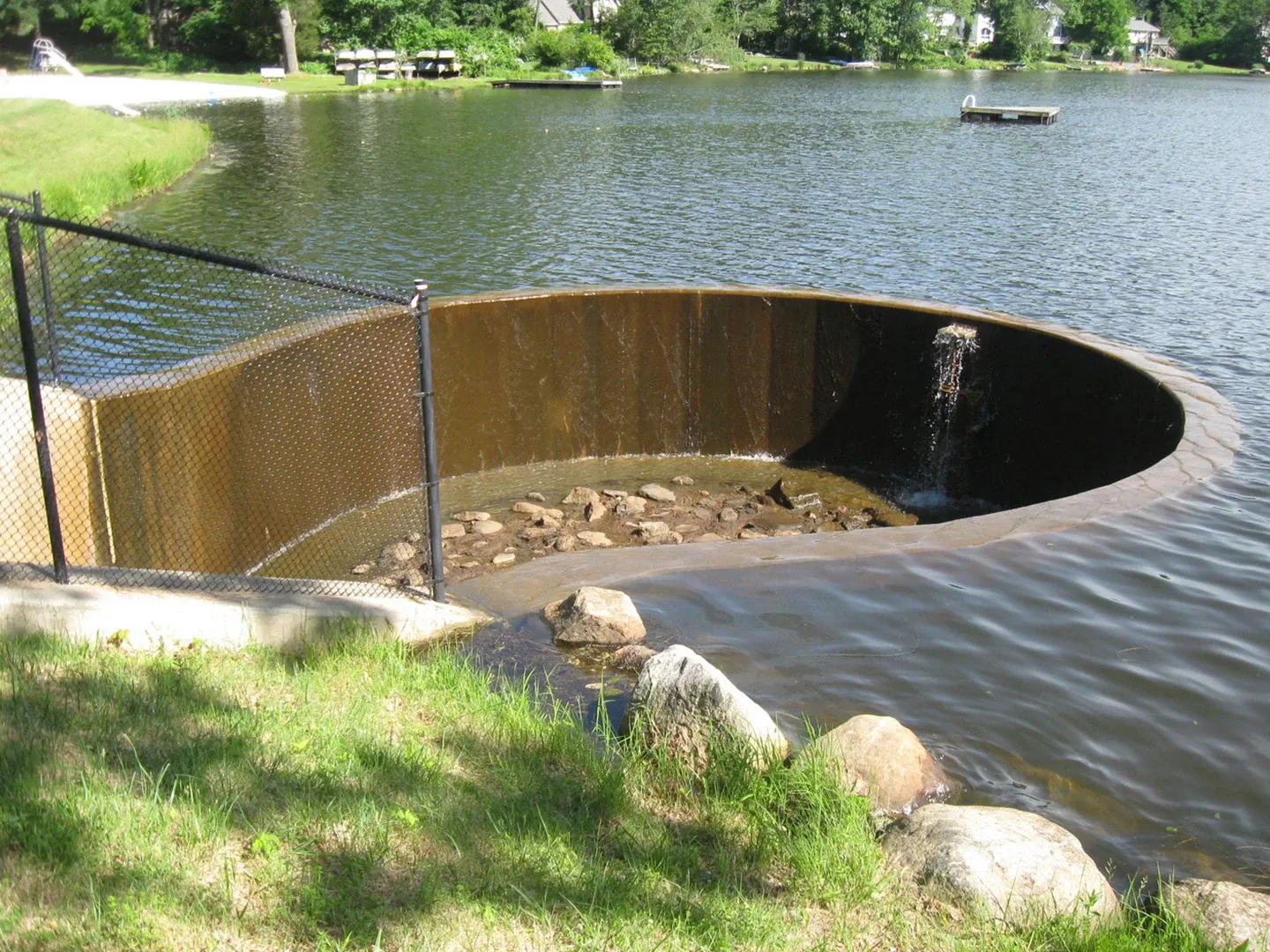 A large hole in the ground near some water.