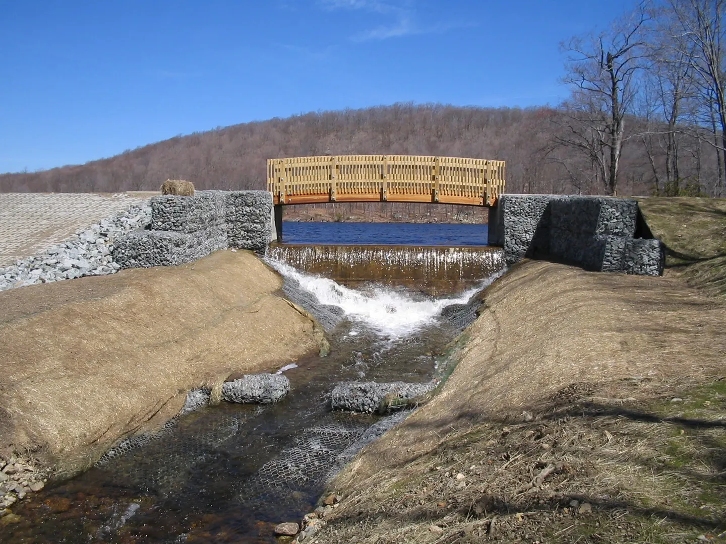 A bridge over water flowing into the ground.