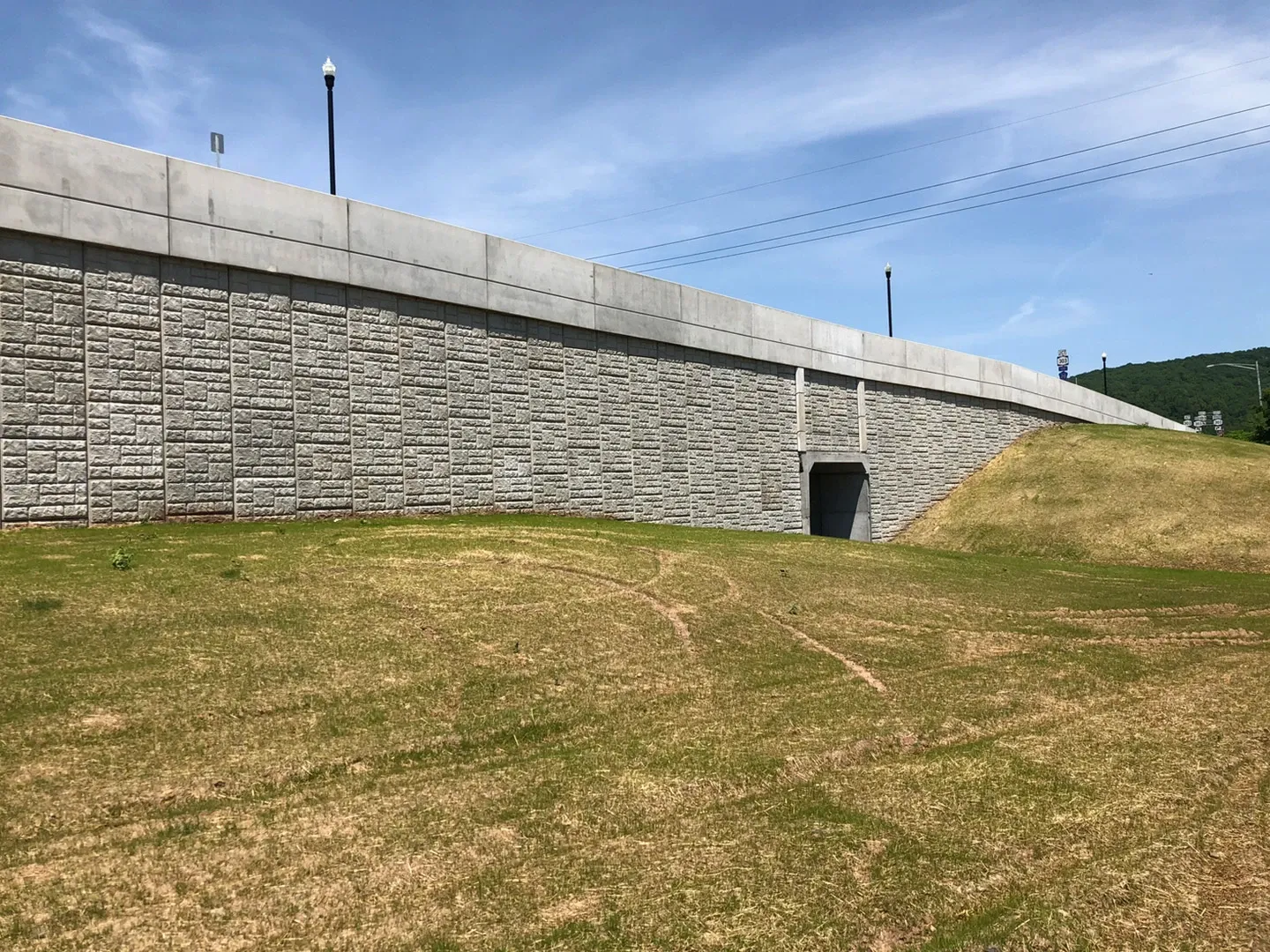 A large concrete wall with a fence around it.